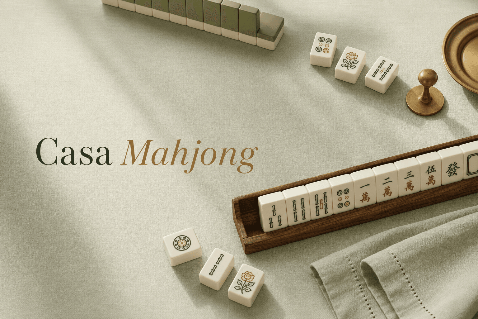 Ivory and sage mahjong tiles resting on a walnut rack beside brass accents and linen napkins